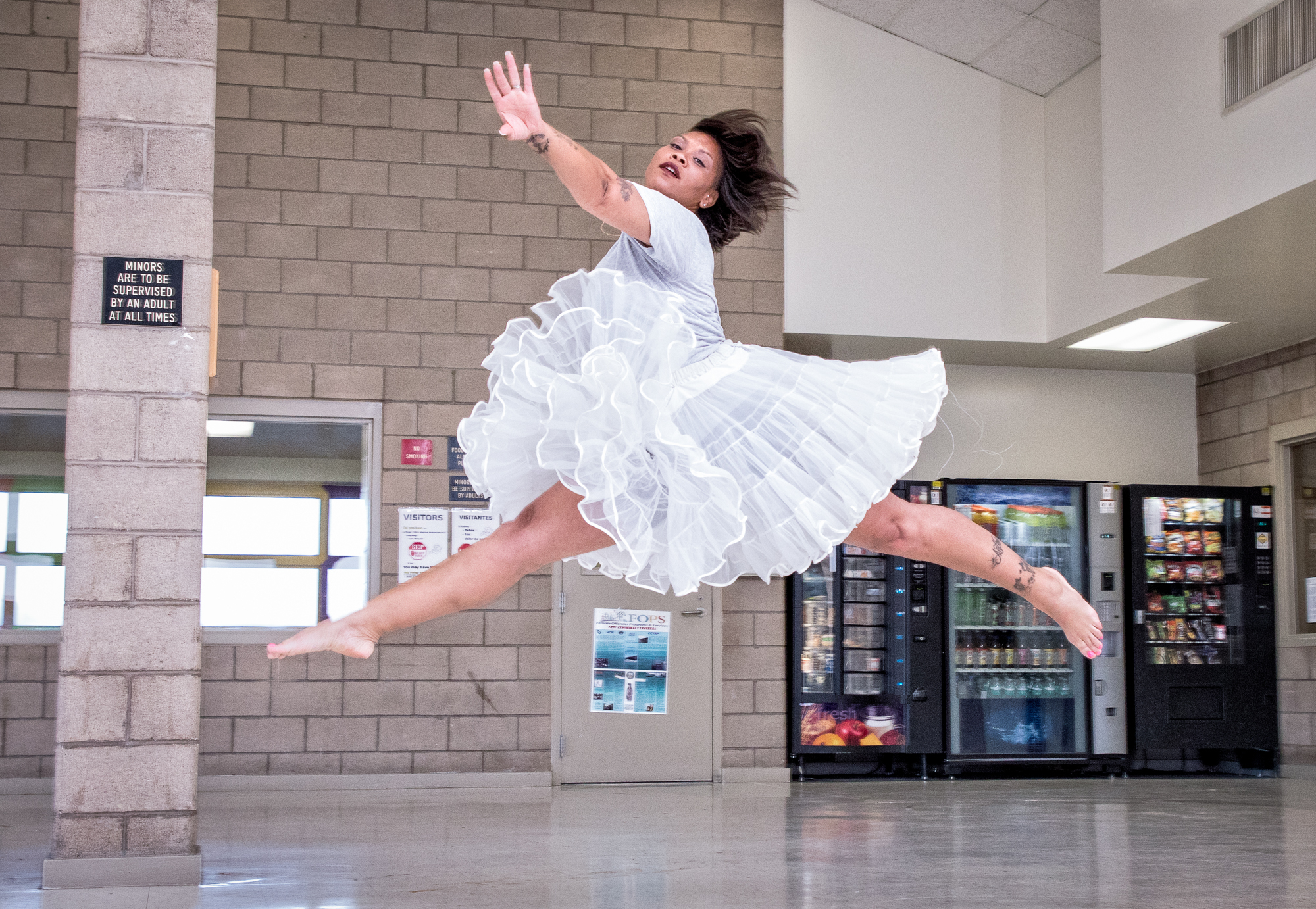 A dance student leaps in a visiting room, at Central California Women's Facility